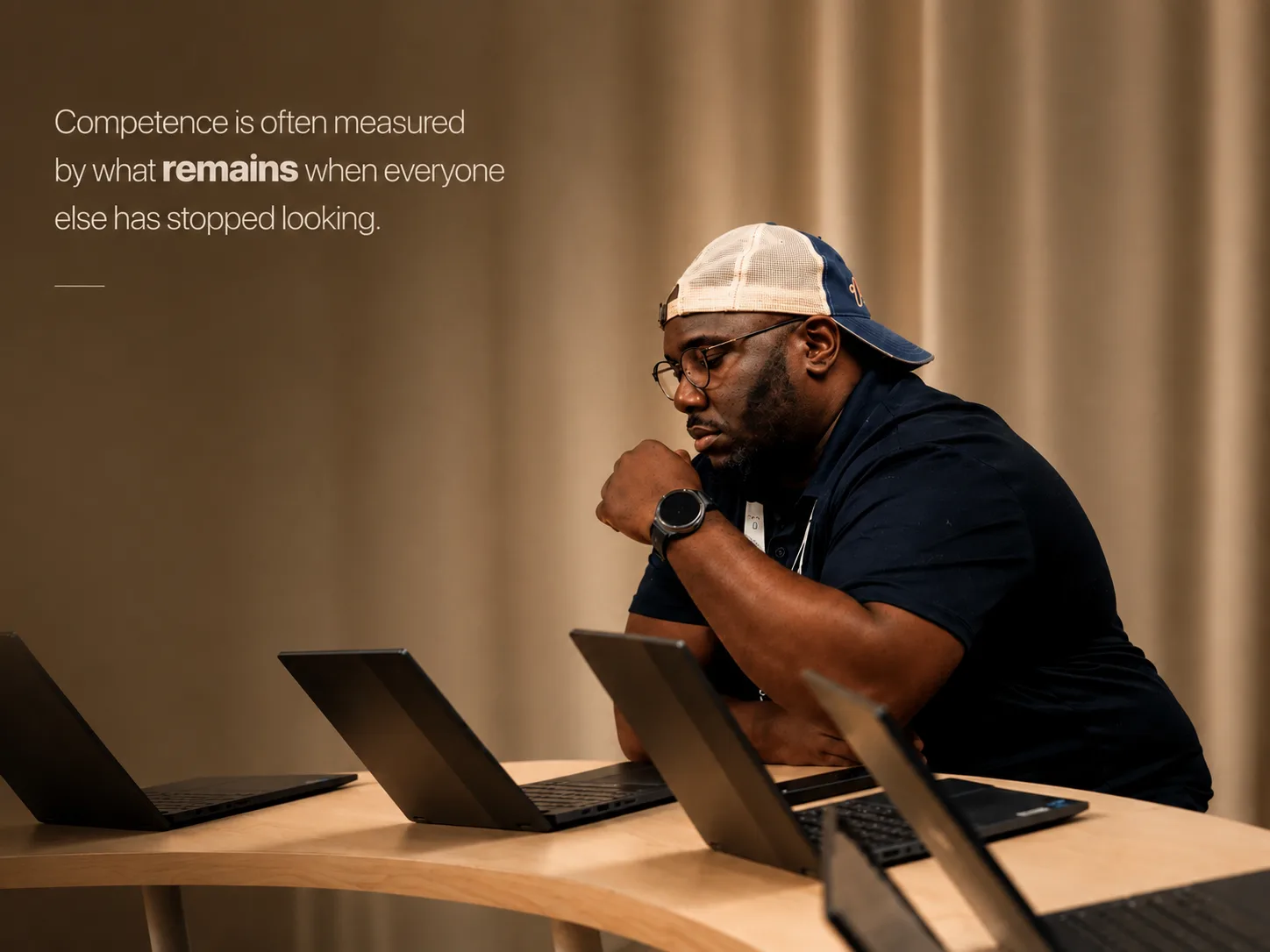 Willard Wells thoughtfully reviewing several laptops
